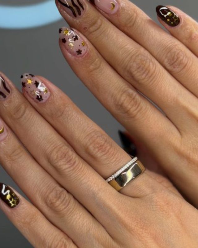 Uñas café con estrellas doradas